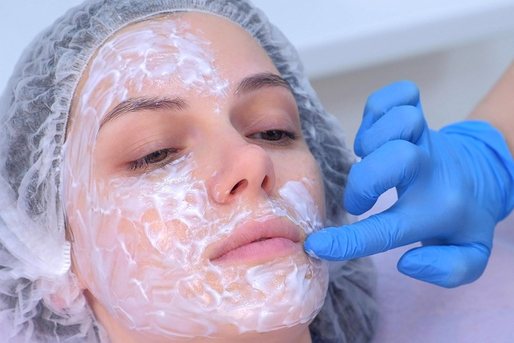 Woman applying BLT numbing cream to patient's face